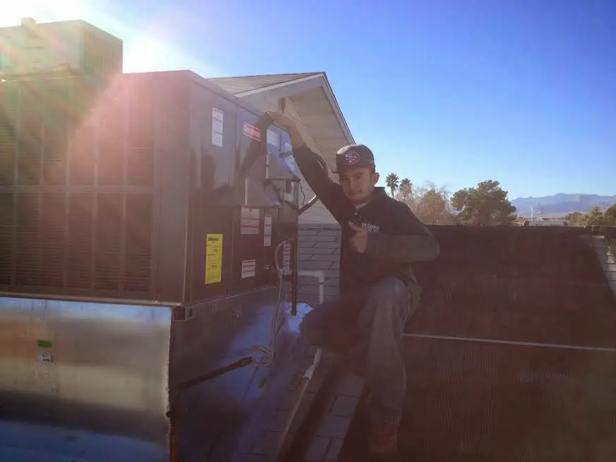 HVAC technician performing Air Duct Repair on a rooftop unit in Georgetown